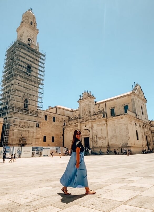 ragazza cammina sorridendo nella piazza del Duomo di Lecce in Puglia