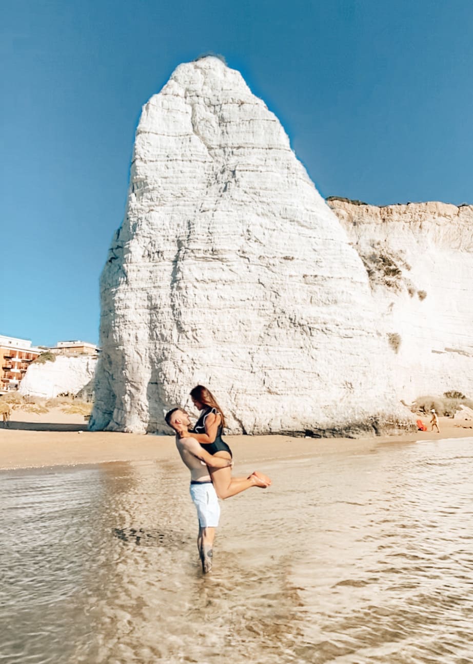 ragazzo prende in braccio fidanzata nella spiaggia più instagrammabile dove fare foto a Vieste
