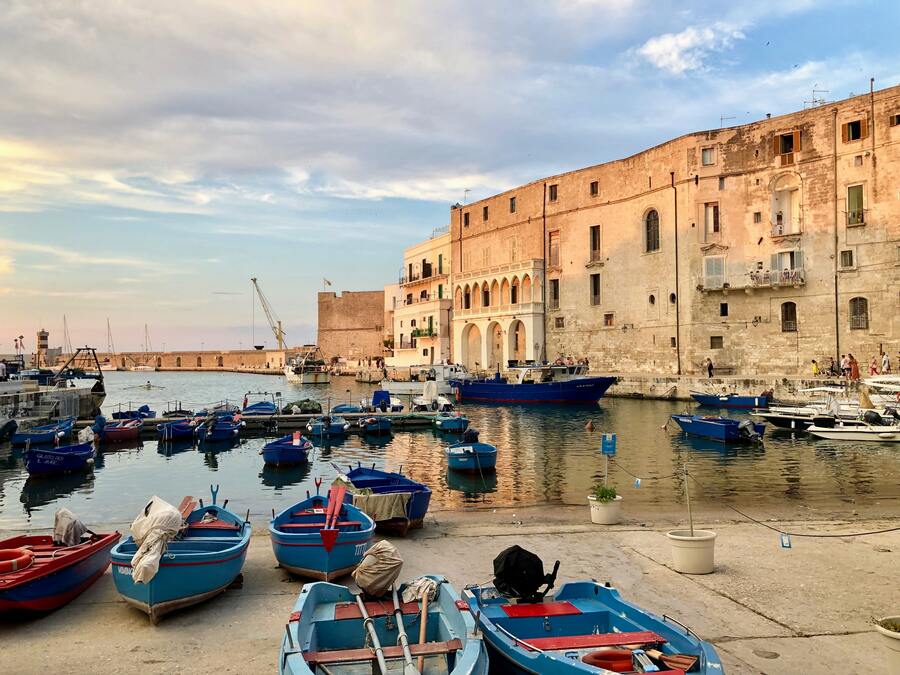 Barche colorate nel porto antico di Monopoli in Puglia con Palazzo Martinelli nello sfondo da vedere in un giorno a Monopoli