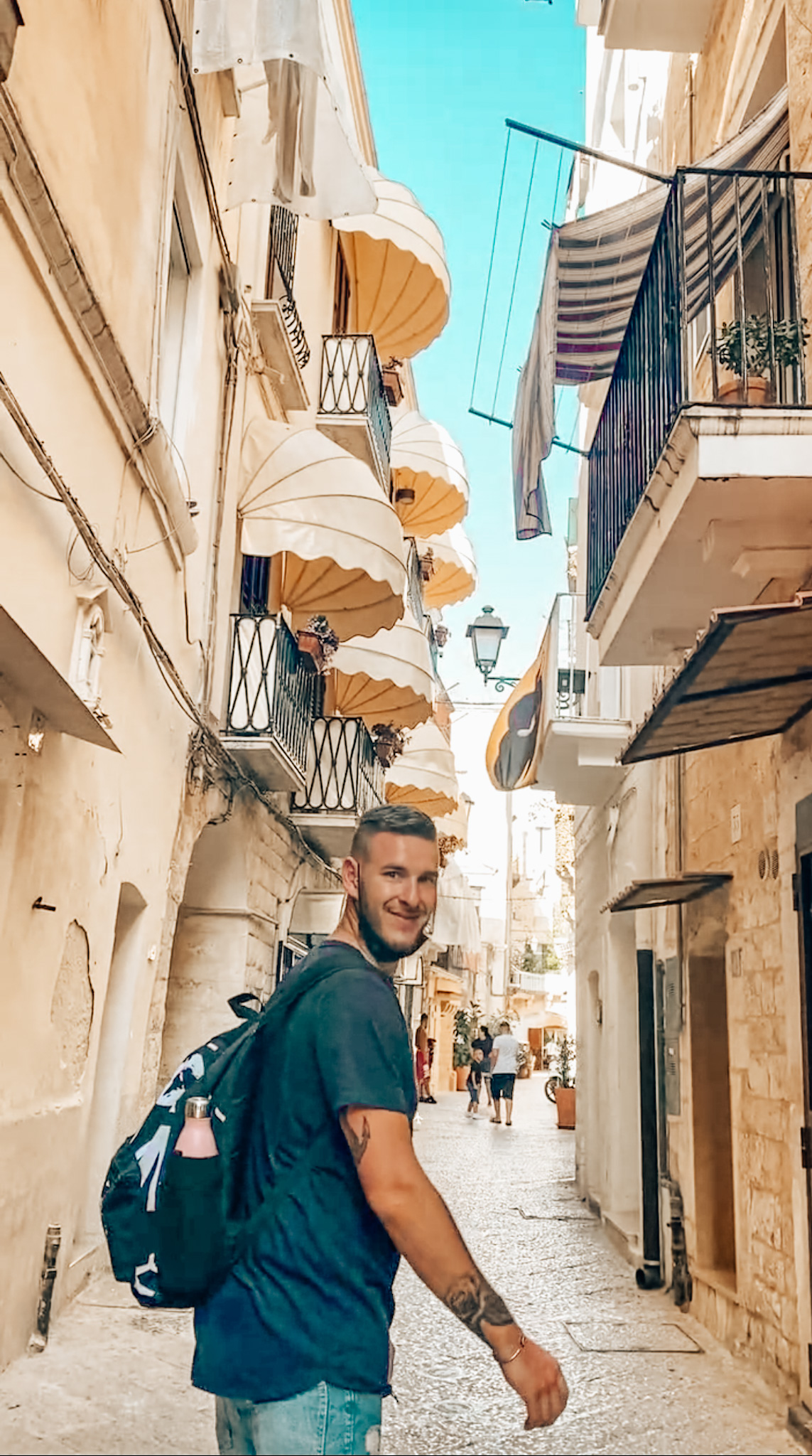 ragazzo passeggia felice in un vicolo da vedere a Bari in un giorno